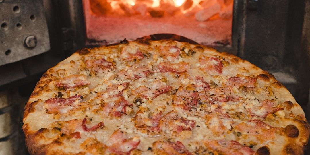 pepe's pizza going into an oven